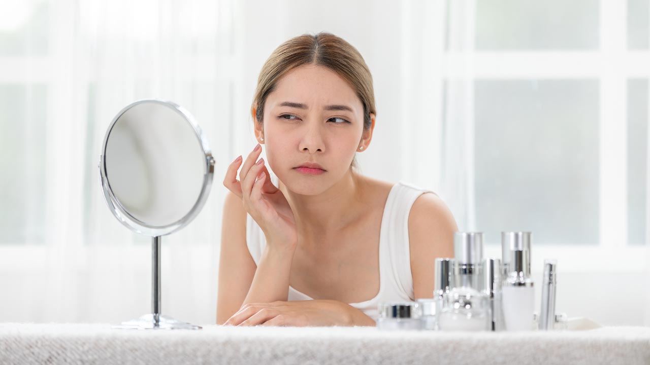 A woman checking her face in the mirror