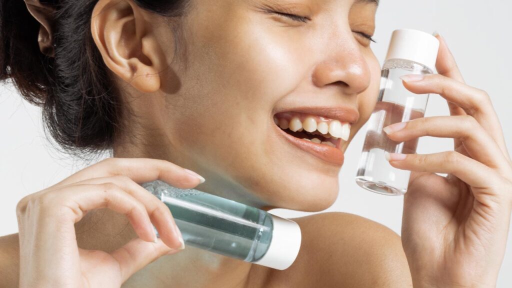 A woman holding products with active acne fighting ingredients