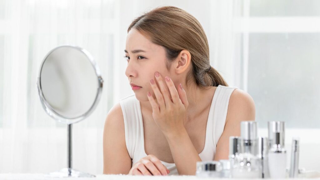 A woman with dry skin looking at the mirror
